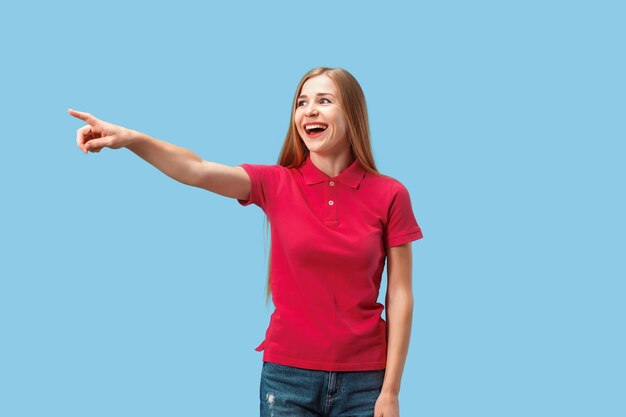 smiling business woman point you, want you, half length closeup portrait on blue studio background.