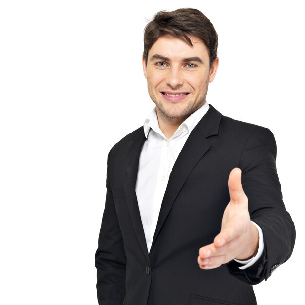 Smiling businessman in black suit gives handshake isolated on white.