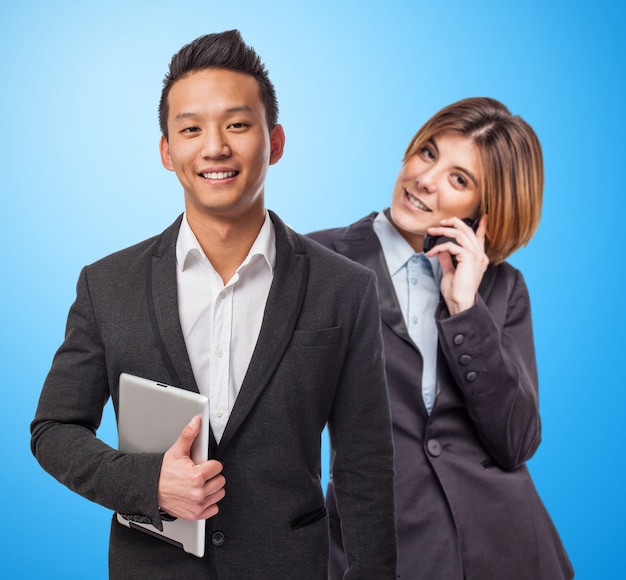 Smiling businessman holding his tablet next to his partner