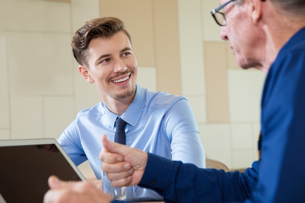 Smiling Businessman Listening to Senior Man