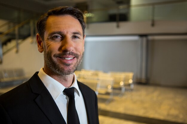 Smiling businessman standing in the airport terminal