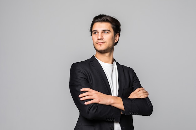 Smiling businessman standing with arms folded isolated on a white