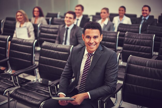 Smiling businessman with co-workers background