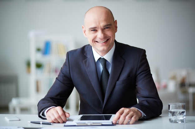 Foto gratuita uomo d'affari sorridente con tavoletta digitale