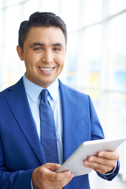 Free photo smiling businessman with a touchpad