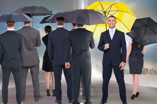 Smiling businessman with yellow umbrella