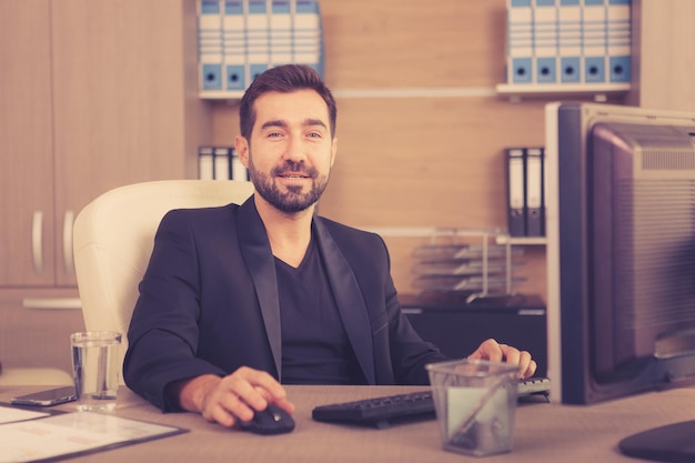 Foto gratuita sorridente uomo d'affari che lavora nel suo ufficio. imprenditore in ambiente professionale