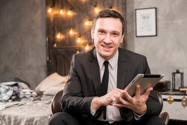 Smiling businessman working on tablet