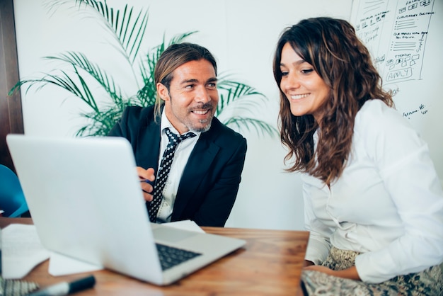 Smiling businessman working with her fellow