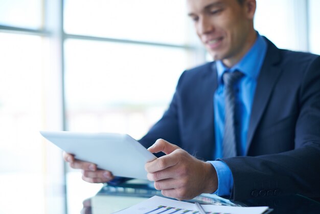 Smiling businessman working with a tablet