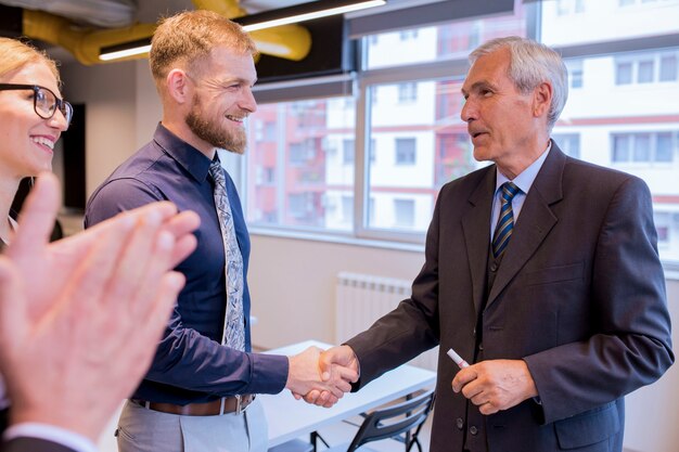 Smiling businesspeople shaking hands during a meeting in the office