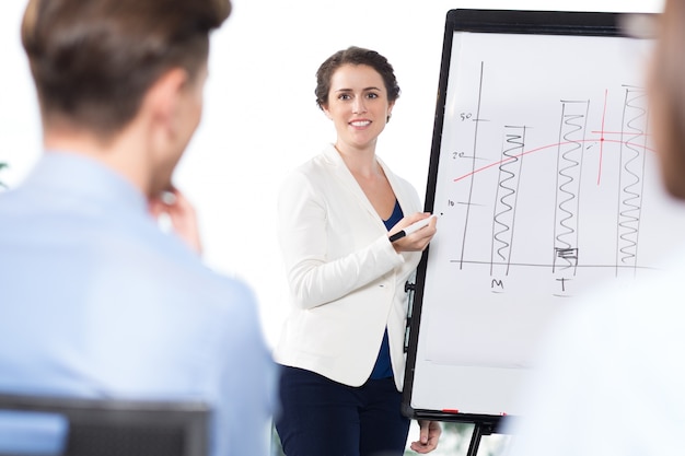 Smiling Businesswoman Presenting Chart to Audience