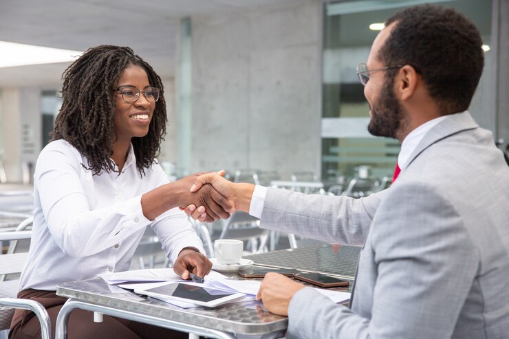 Free Photo smiling businesswoman shaking hands with partner