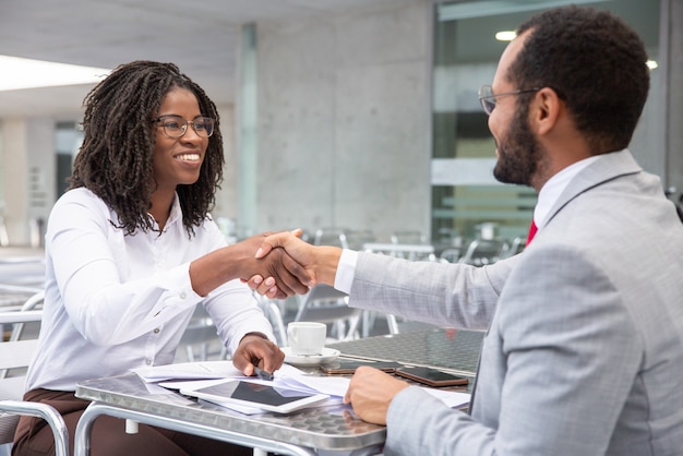 Smiling businesswoman shaking hands with partner