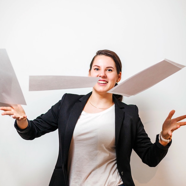 Smiling businesswoman throwing papers