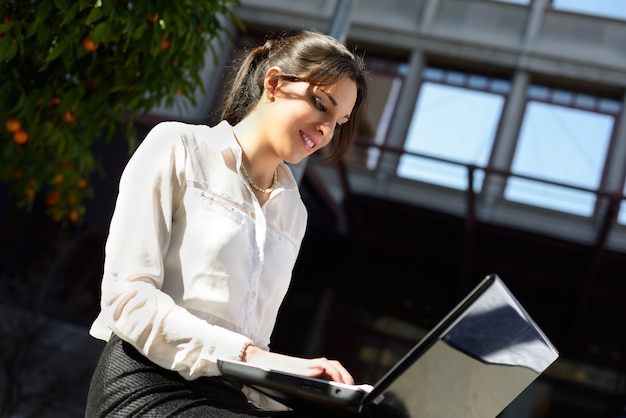 Smiling businesswoman typing on laptop