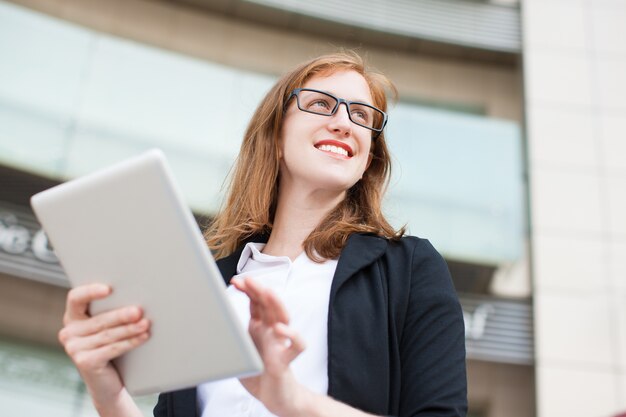 Smiling businesswoman using touchpad outdoors