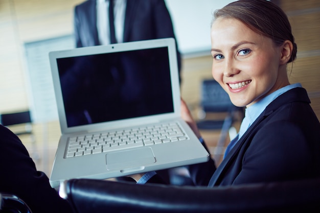 Foto gratuita sorridente imprenditrice con il computer portatile