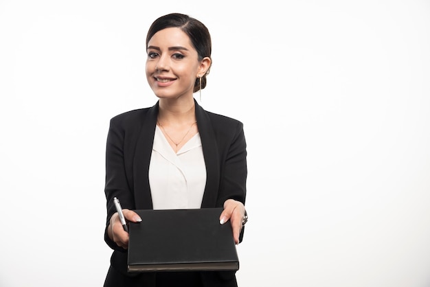 Smiling businesswoman with pencil showing notebook.