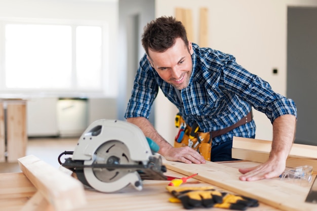 Free photo smiling carpenter checking result of his work