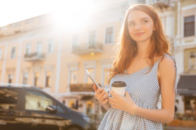 Smiling casual girl holding pc tablet and cup of coffee