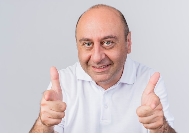 Smiling casual mature businessman doing you gesture at camera isolated on white background