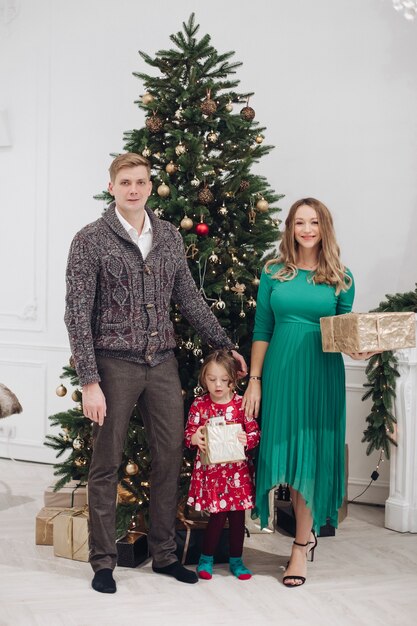 Smiling caucasian family next to christmas tree