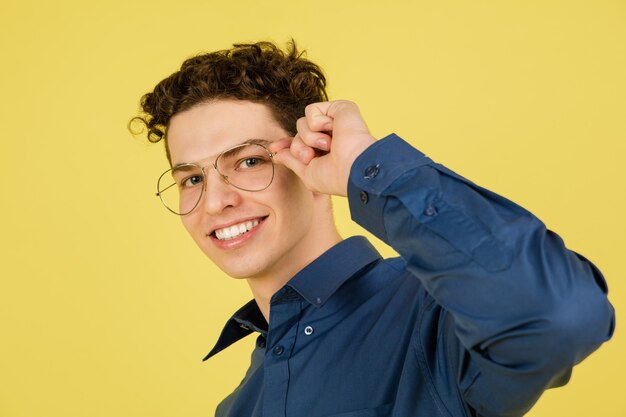 Smiling. Caucasian handsome man's portrait isolated on yellow  background with copyspace.