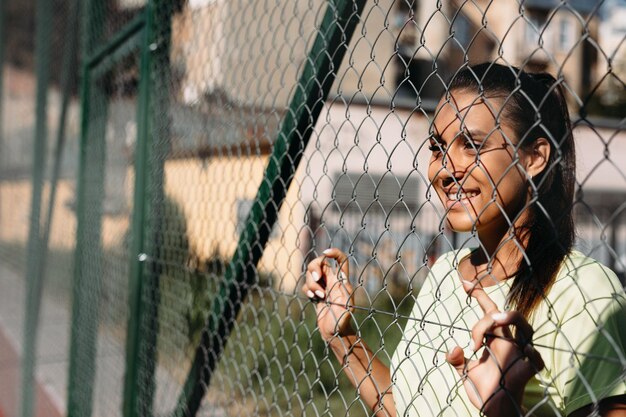 Signora affascinante sorridente che si gode la giornata di sole allo stadio