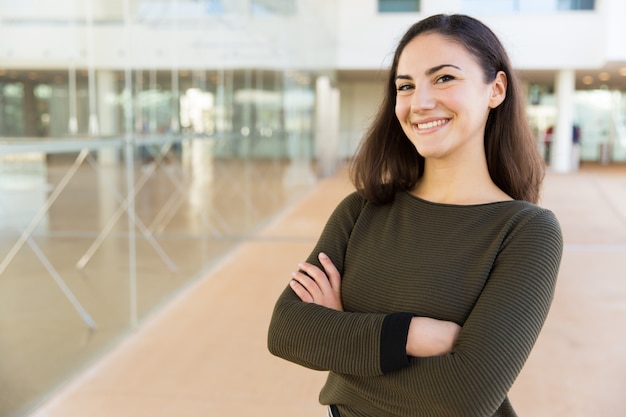 Smiling cheerful Latin woman posing with arms folded