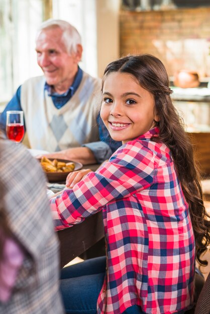 Smiling child sitting near elderly man