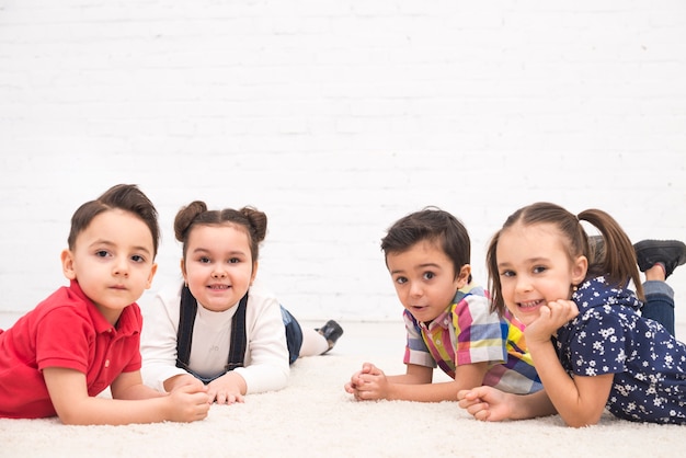 Free photo smiling children lying down