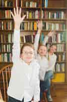 Бесплатное фото Улыбающиеся дети кладут руки в библиотеку