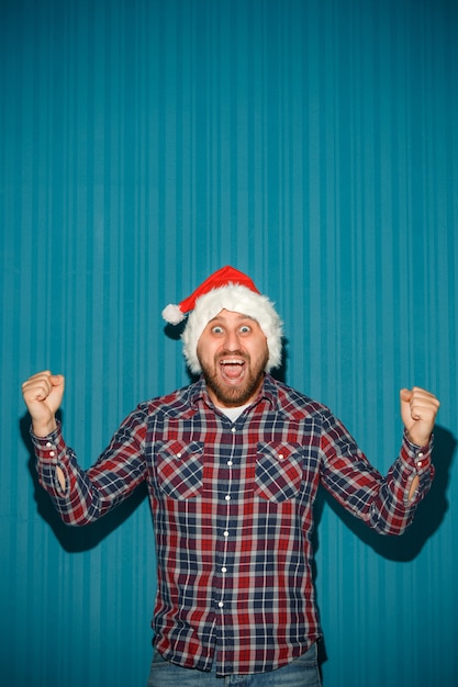 Foto gratuita uomo sorridente di natale che porta un cappello della santa