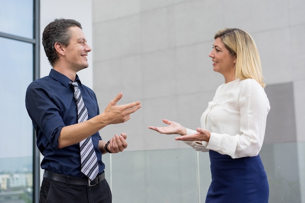 Foto gratuita colleghi sorridenti che chiacchierano e che gesturing all'aperto.