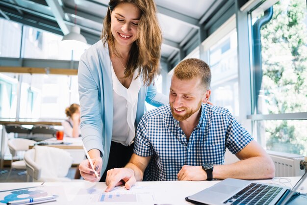 Smiling colleagues making notes on plans