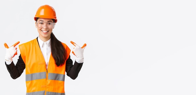 안전모 장갑과 안경을 쓴 자신감 있는 아시아 여성 수석 건설 엔지니어 미소