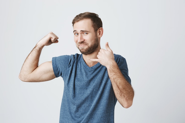 Free Photo smiling confident male fitness instructor flex biceps and make phone call gesture