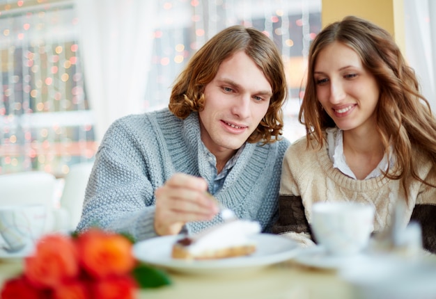 Smiling couple eating a cake