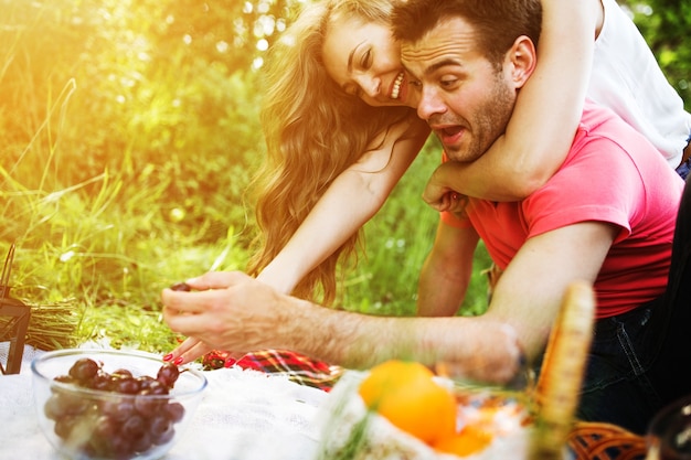 Smiling couple eating grapes