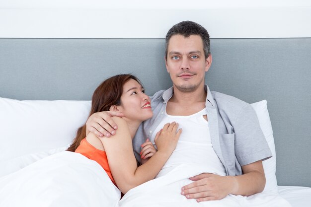 Smiling Couple Embracing and Lying in Bed