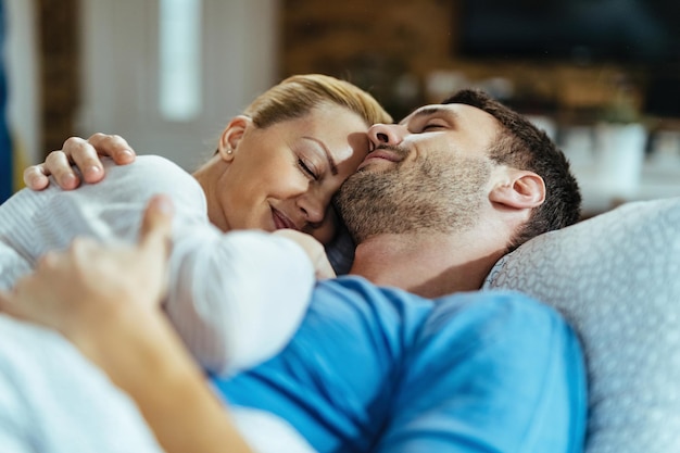 Smiling couple embracing while sleeping in the bedroom