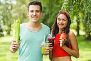 Foto gratuita frullati di avocado e mela della tenuta delle coppie sorridenti a disposizione