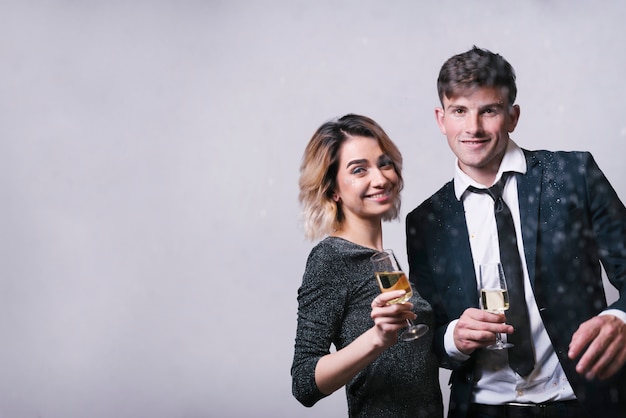 Free photo smiling couple holding glasses of champagne