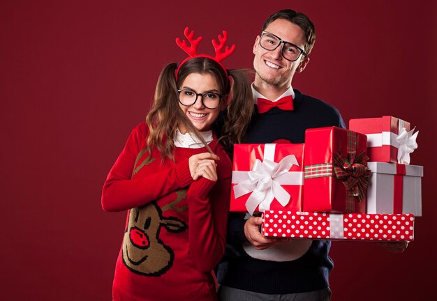 クリスマスプレゼントのスタックを保持している笑顔のカップル