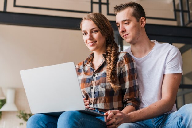 Free photo smiling couple in love looking at laptop