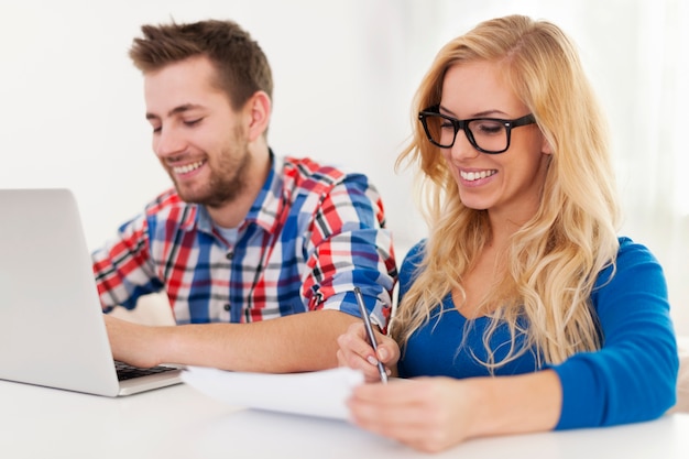 Smiling couple paying bills at home