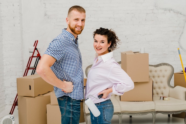 Free photo smiling couple posing in new flat