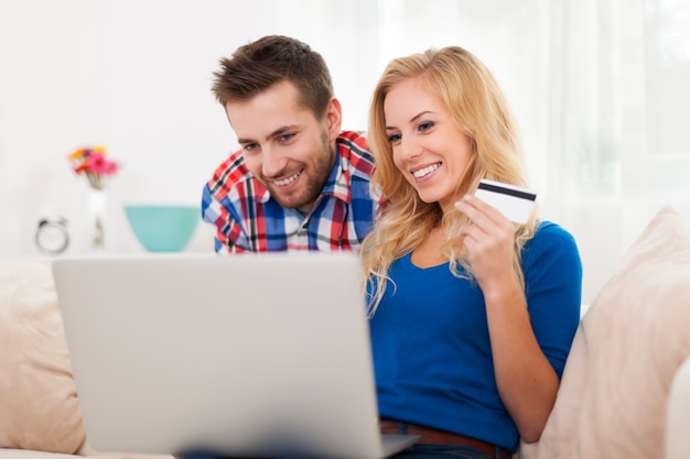 Улыбающаяся пара во время покупок в Интернете