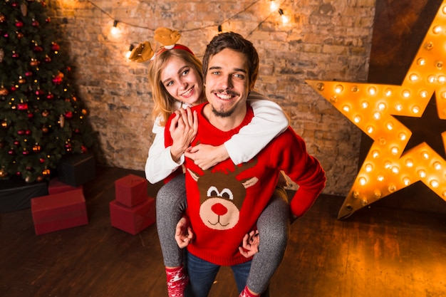 クリスマススターの装飾の前に立っている笑顔のカップル